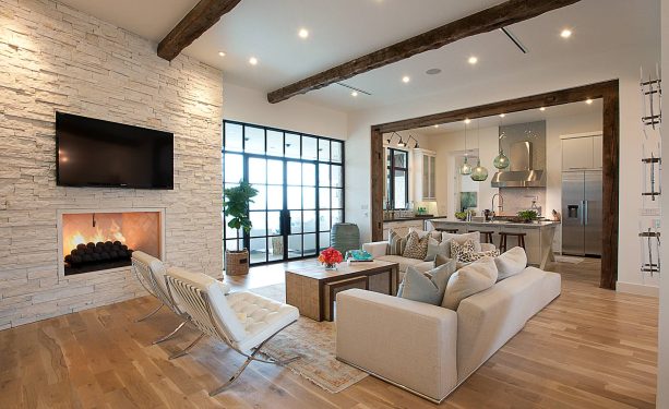 an open plan living room and kitchen with light wood floor