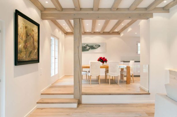 bright wood floor looks matching with the white-washed post and beams in a transitional split-level living and dining rooms