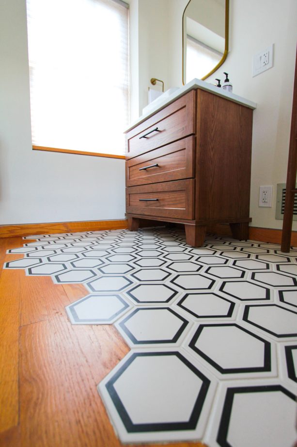 hardwood and black and white hexagonal tile floor combination in a transitional bathroom design