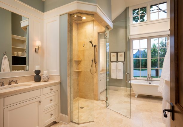 the combination of limestone tile and grey walls in the bathroom