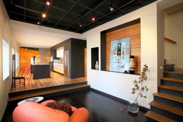 the combination of medium and black wood floor in an open-plan kitchen and family room