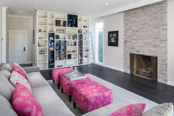 the living room has the same wood floor but looks different because of the popping pink accents