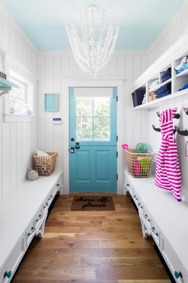 the mudroom of the beach-style interior with medium-tone oak wood flooring