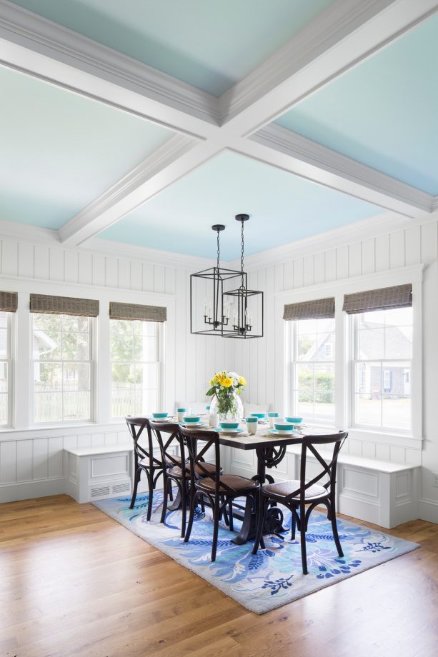 the oak floor is decorated with a rug in the dining area to emphasize function