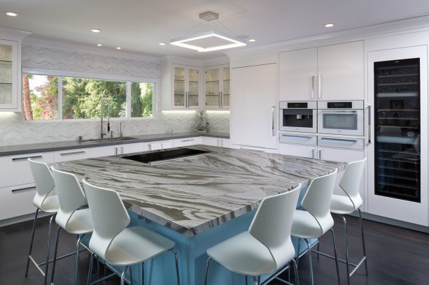 the open kitchen shares the same type of dark wood flooring with the dining room