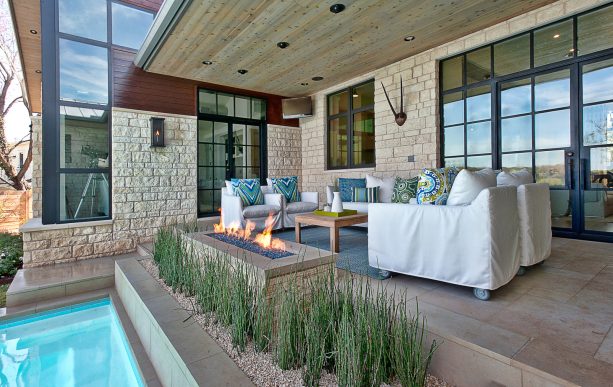 the use of beige natural stone floor in the transitional covered patio area