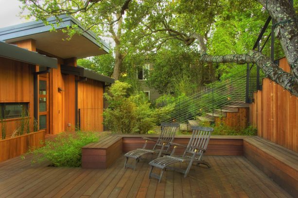 a deck stair with metal and cable for the railing