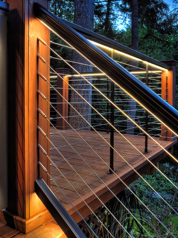 a wood and cable deck stair railing with under-cap LED light