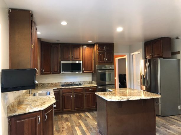 before the refacing took place, the cabinets has brown color and arched, raised-panel doors