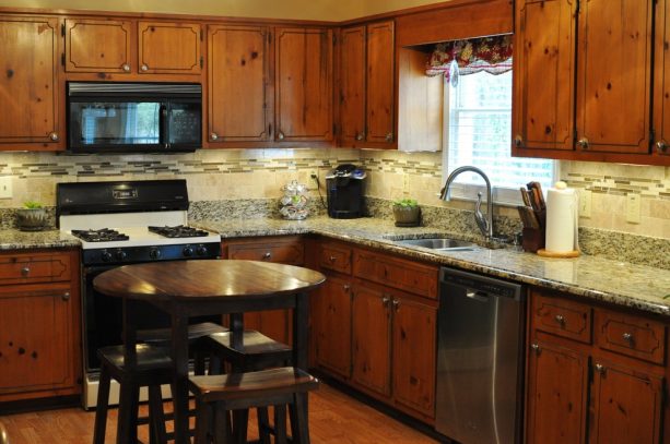 before reface - clear-coated cabinets paired with white and grey theme countertops and backsplash