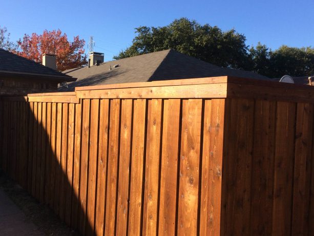 a cedar board on board fencing with trim and cap on the upper part