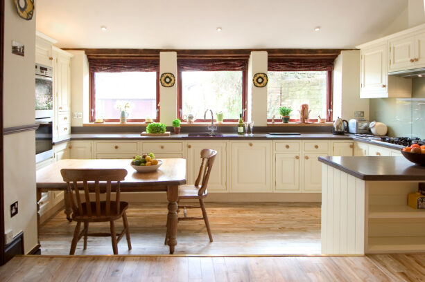 a warm and cozy traditional kitchen with three garden windows over the sink