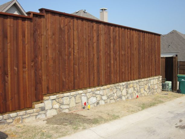 board on board fencing with flagstone brick retaining wall