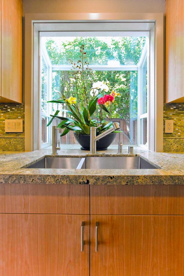the orchids in the garden window creates a gorgeous tropical view in the kitchen interior
