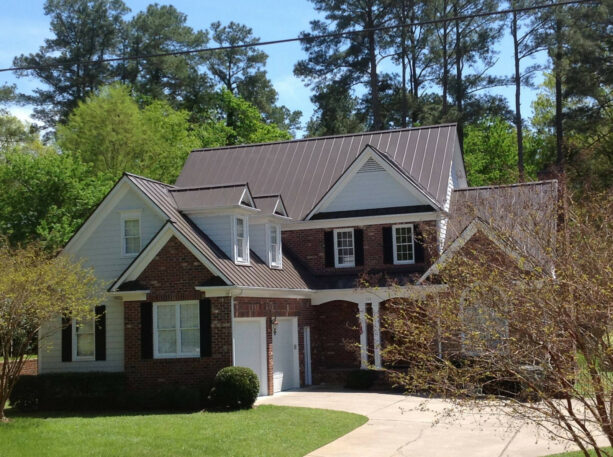 a cozy exterior with the combination of metal roof in burnished slate and exposed brick walls