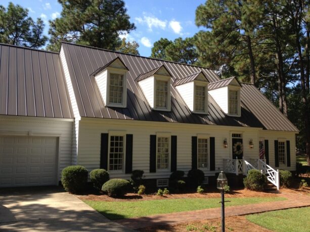 a traditional exterior looks beautiful because of the burnished slate metal roofing that is paired with warm white wall siding