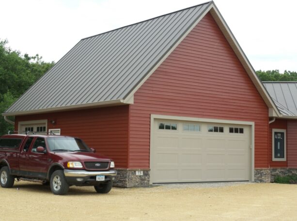 close up picture of a brick red wall siding and a metal roof in burnished slate color