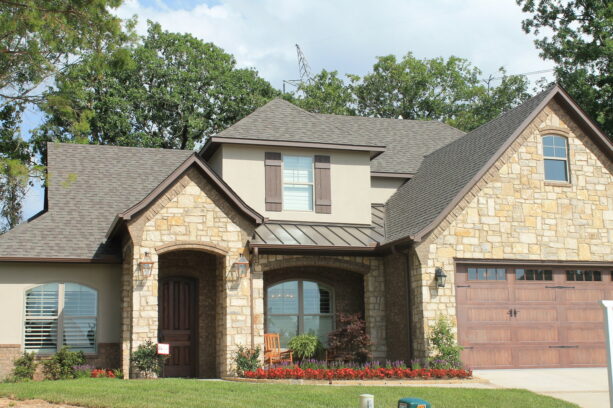 the beautiful combination of burnished slate metal roof and regular shingles in a transitional exterior